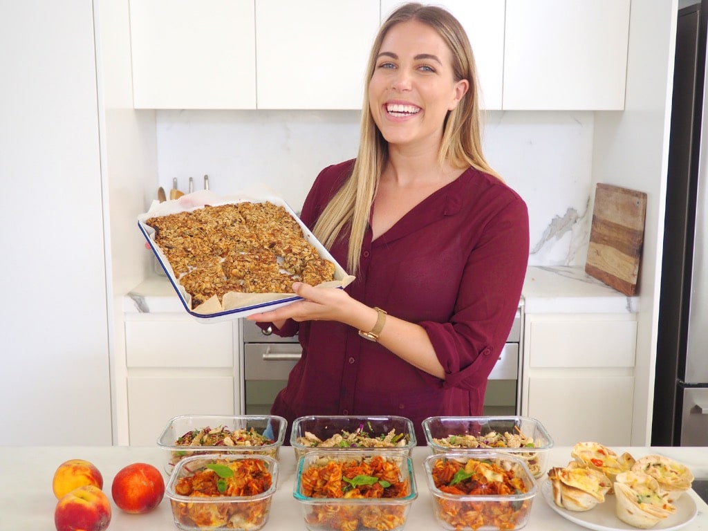 Lyndi Cohen in her kitchen with multiple packed food containers after a successful Meal Prep Power Hour.