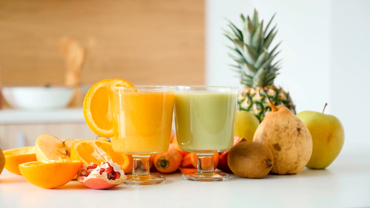Yellow and green fruit juice in two glasses with fresh fruit on a table. Image: Unsplash