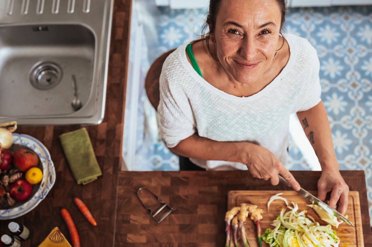 Woman in kitchen doing weekly meal prep with a diverse range of foods