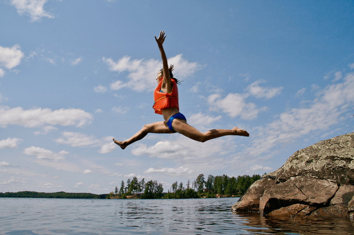 Woman with life vest jumping into water
